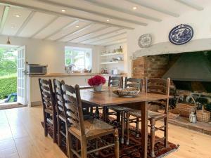 eine Küche und ein Esszimmer mit einem Holztisch und Stühlen in der Unterkunft Marshalls Farm in Aston Ingham