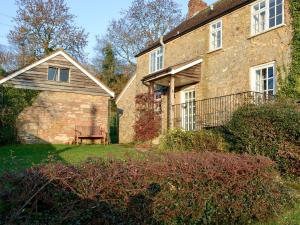 an old brick house with a bench in the yard at Marshalls Farm in Aston Ingham