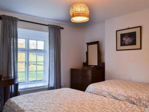 a bedroom with two beds and a dresser and a window at Marshalls Farm in Aston Ingham