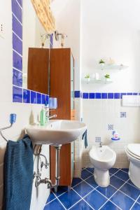 La salle de bains bleue et blanche est pourvue d'un lavabo et de toilettes. dans l'établissement Monolocale la casa dei sogni, à Chiaravalle