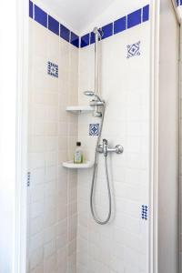 bagno con doccia e piastrelle bianche e blu di Monolocale la casa dei sogni a Chiaravalle