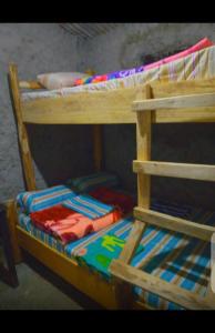 a wooden bunk bed with a colorful comforter on it at Sunrise homestay Sipi in Kapchorwa