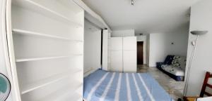 a room with white shelves and a blue floor at Studio Mer Montagne in Roquebrune-Cap-Martin