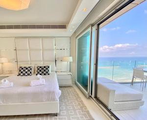 a bedroom with a bed and a view of the ocean at Amazing Sea view APT with parking at Royal Beach - By Beach Apartments TLV in Tel Aviv