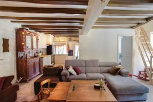 una sala de estar con un sofá y una mesa en LA BERGERIE Appartement 1, en Mont-de-Lans