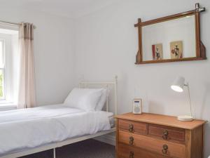 a bedroom with a bed and a mirror and a dresser at Tyn Y Coed in Bettws-Evan