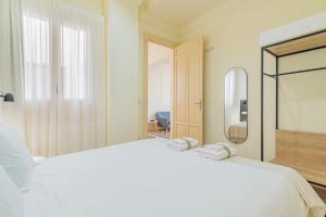 a bedroom with a large white bed and a mirror at Mosaiko Homes Catedral Granada in Granada