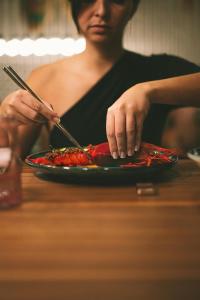 a woman preparing a plate of food on a table at Kimpton Aysla Mallorca by IHG in Santa Ponsa