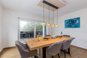 jadalnia z drewnianym stołem i krzesłami w obiekcie Villa LIO with private pool w mieście Linardići