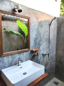 a bathroom with a white sink and a mirror at EKUKU lake houses in Kumbalgama