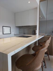 a kitchen with a counter with chairs around it at MyHome - Studio de Luxo próximo ao Shopping Iguatemi in Porto Alegre