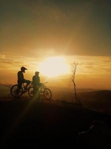 two people riding bikes on a hill at sunset at Willa Pod Janowcem in Stronie Śląskie