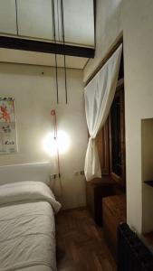 a bedroom with a bed and a light and a window at Appartamento Torre della Buca in Prato