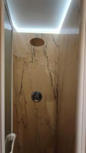 a shower in a bathroom with a marble wall at Appartamento Torre della Buca in Prato