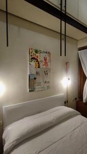 a bedroom with a white bed and a lamp at Appartamento Torre della Buca in Prato