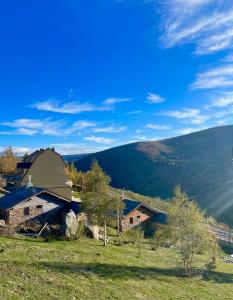 a farm with a barn on a grassy hill at Apartamento en estación de esquí y montaña alto campoo in Brañavieja
