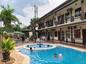 a group of people swimming in a swimming pool at DIAKOPES INN in Puerto Princesa City