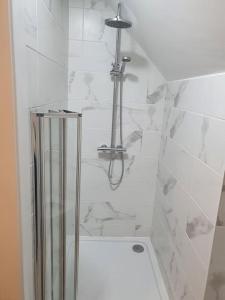 a shower in a bathroom with white tiles at The Loft, Killybegs in Donegal