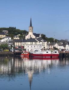 deux bateaux sont amarrés dans un port avec une ville dans l'établissement The Loft, Killybegs, à Donegal