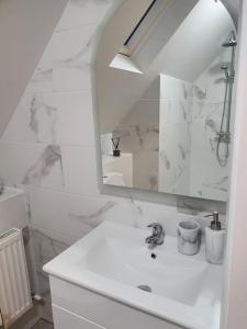 uma casa de banho branca com um lavatório e um espelho em The Loft, Killybegs em Donegal