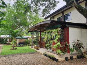 una casa con una puerta roja y algunas plantas en DIAKOPES INN en Puerto Princesa