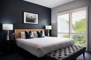 um quarto com uma cama grande e uma janela em Lake Orchard Villas em Daylesford