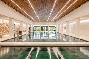 a swimming pool in a building with a ceiling at Kimpton Aysla Mallorca by IHG in Santa Ponsa