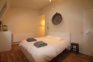 a bedroom with a white bed with towels on it at Duplex de 3 chambres en plein centre ville - 82/3A in Liège