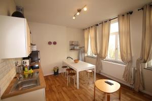 eine kleine Küche mit einem Tisch und einem Waschbecken in der Unterkunft Duplex de 3 chambres en plein centre ville - 82/3A in Lüttich