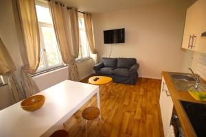 eine Küche und ein Wohnzimmer mit einem Sofa und einem Tisch in der Unterkunft Duplex de 3 chambres en plein centre ville - 82/3A in Lüttich