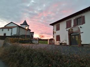 um edifício com uma torre de relógio em frente a um pôr-do-sol em Gîte Le Relais de la Source em Caro