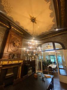 a dining room with a chandelier and a fireplace at The Museum - Au Lit, Jérôme! in Antwerp