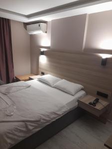 a bedroom with a white bed and two lamps at Moon Hotel Şirinevler in Istanbul