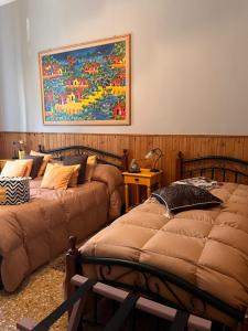 a bedroom with two beds and a painting on the wall at Nuovo Cortile Palermo Bed and Breakfast in Palermo