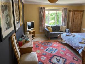 a bedroom with a bed and a living room with a couch at Orchard Paddocks in Guildford