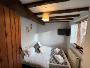 a bedroom with a bed with white sheets and pillows at King Charles Barns Nr Blists Hill in Telford