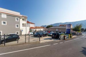 a parking lot with cars parked next to a building at Apartments Crnekovic Tomislava 8A in Baška