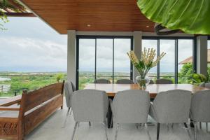 a dining room with a table and chairs at The Lavana Villa Puri Hawila Jimbaran - 5 Bedroom Villa in Jimbaran