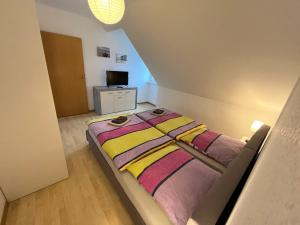 a small bedroom with a bed with a yellow and pink blanket at Sonnenschein in Uelzen