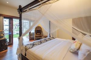 a bedroom with a bed with a canopy at The Lavana Villa Puri Hawila Jimbaran - 5 Bedroom Villa in Jimbaran