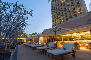a row of chairs and tables in front of a building at SUN & MOON, Riverside Hotel in Phnom Penh