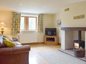 a living room with a couch and a fireplace at The Old Dairy - Ukc3413 in Bolton by Bowland