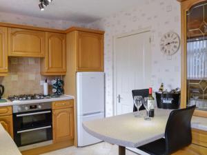 a kitchen with a table and a white refrigerator at Thain House in Banff