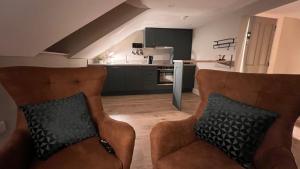 a living room with two chairs and a kitchen at CHAMBERS RISE - City Centre Stays in Derry Londonderry