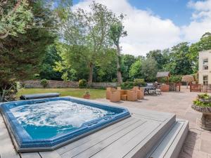 a hot tub in a backyard with a wooden deck at Questeds in Westgate-on-Sea