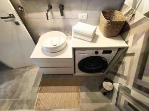 a bathroom with a sink and a washing machine at Blue Holiday da Marco in Letojanni