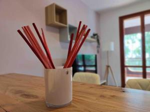 a vase filled with red sticks sitting on a table at Blue Holiday da Marco in Letojanni