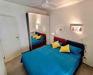 a bedroom with a blue bed with yellow pillows at Blue Holiday da Marco in Letojanni