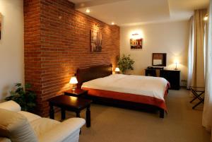 ein Schlafzimmer mit einem Bett und einer Ziegelwand in der Unterkunft Hotel Green Gondola in Pilsen