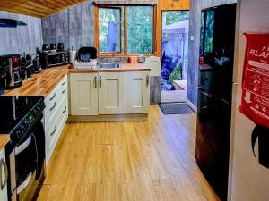 a kitchen with white cabinets and a wooden floor at Wildwood 5 in Beattock